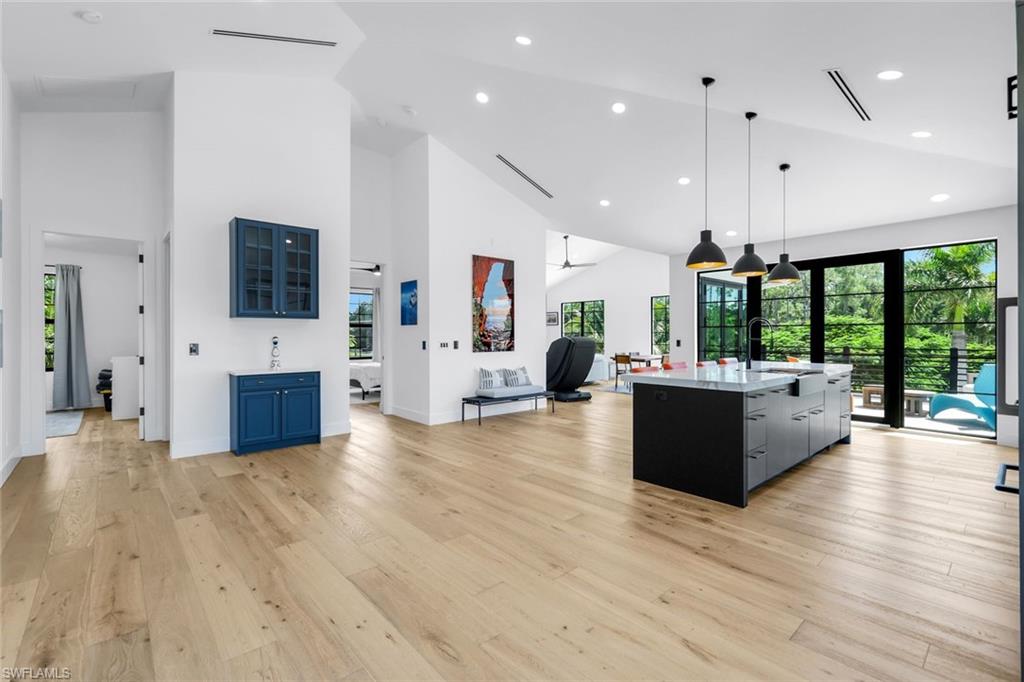 6677 Hunters Road Naples, FL 34109 - Photo 42 of 50 a living room with furniture a flat screen tv and a floor to ceiling window