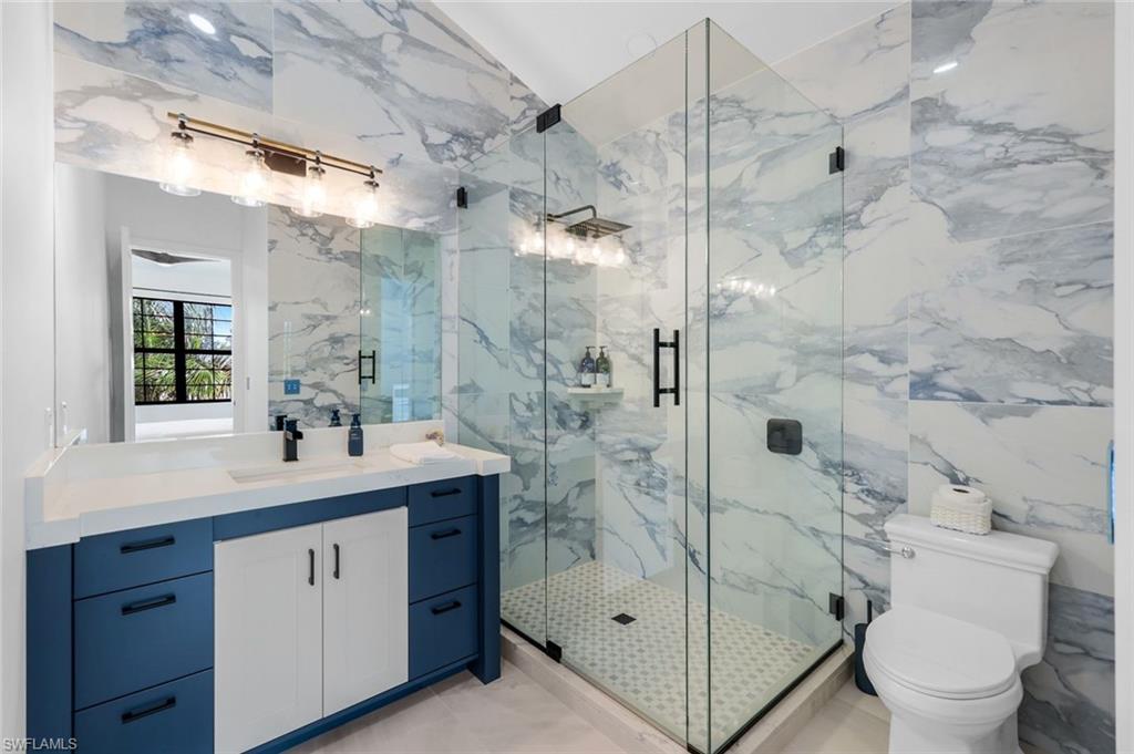 6677 Hunters Road Naples, FL 34109 - Photo 44 of 50 a bathroom with a shower sink mirror and toilet