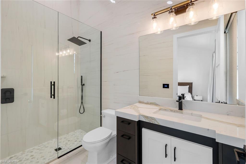 6677 Hunters Road Naples, FL 34109 - Photo 45 of 50 a bathroom with a sink toilet and shower