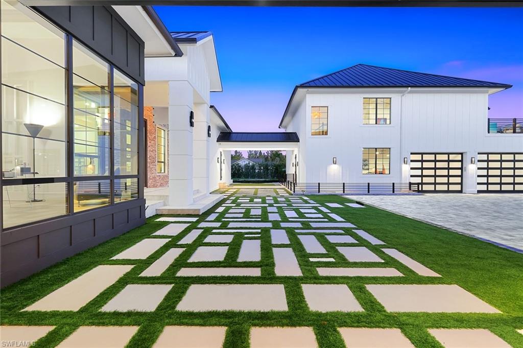 6677 Hunters Road Naples, FL 34109 - Photo 7 of 50 a front view of a house with a yard