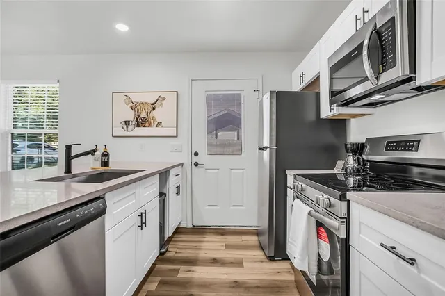 a kitchen with stainless steel appliances granite countertop a stove and a sink