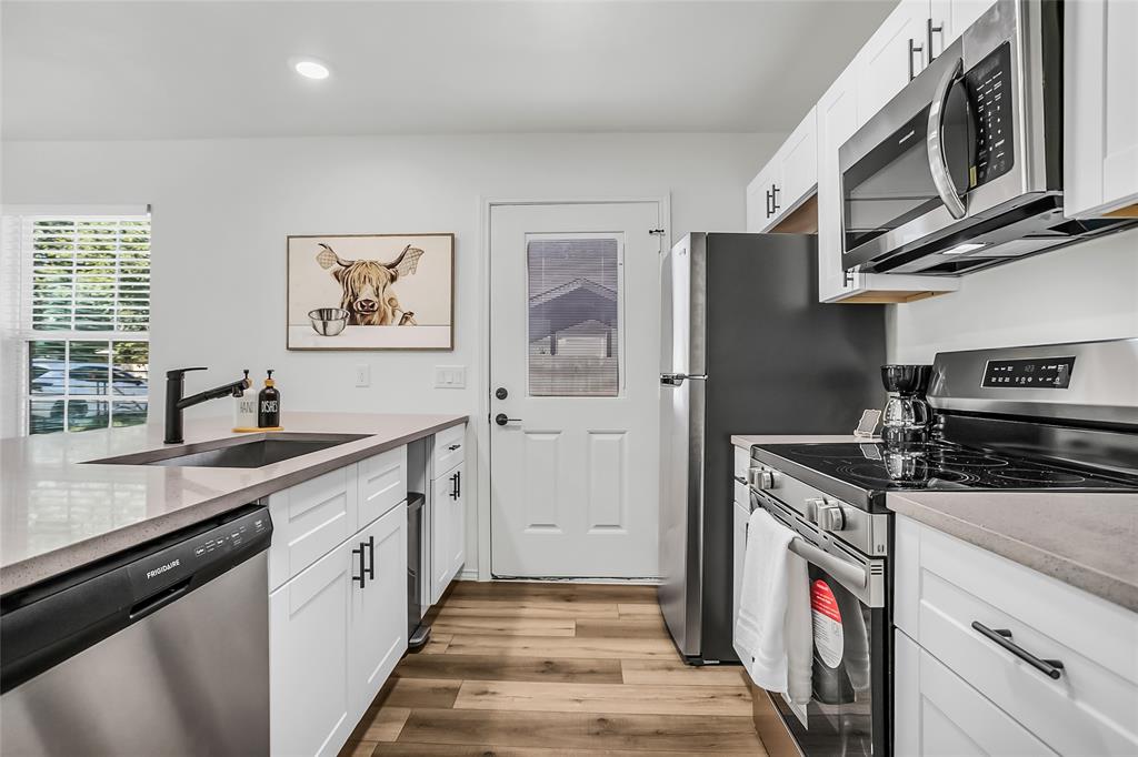 308 South 3rd Street Bonham, TX 75418 - Photo 14 of 19 a kitchen with stainless steel appliances granite countertop a stove and a sink