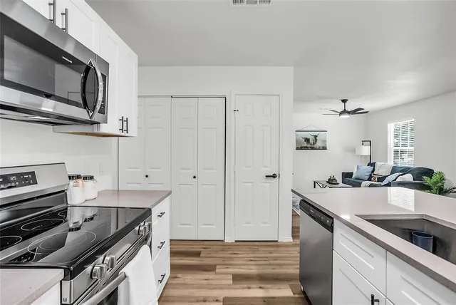 a kitchen with stainless steel appliances a sink stove and cabinets
