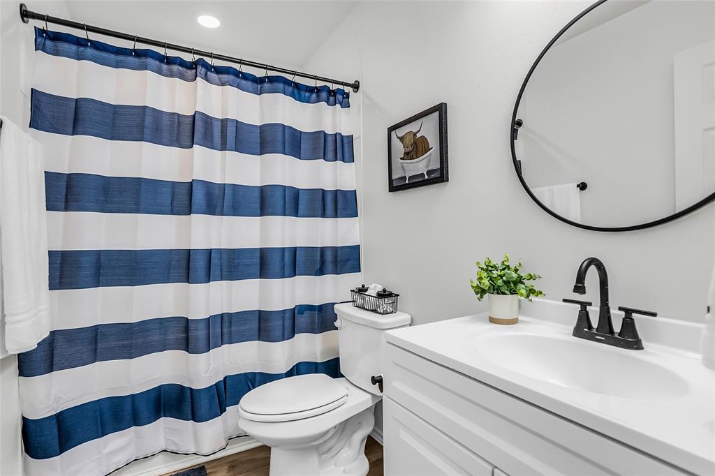 308 South 3rd Street Bonham, TX 75418 - Photo 16 of 19 a bathroom with a sink a toilet and a mirror