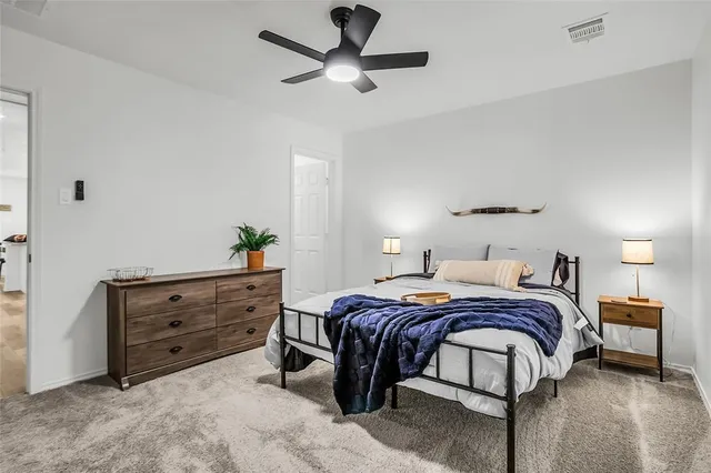 a bedroom with a bed and a ceiling fan