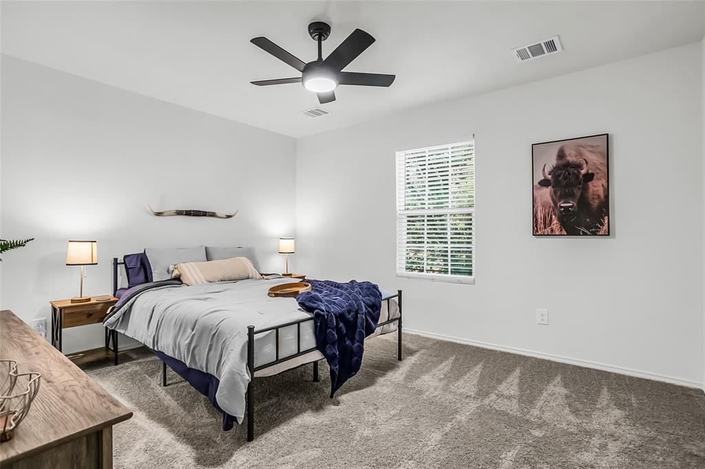 308 South 3rd Street Bonham, TX 75418 - Photo 18 of 19 a bedroom with a bed a painting on the wall and a large window
