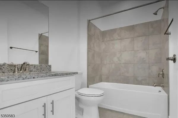 a bathroom with a granite countertop toilet a sink and bathtub