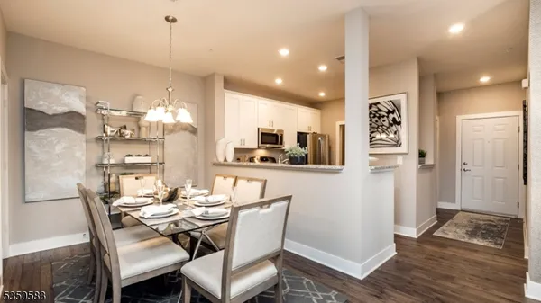 a dining room with stainless steel appliances kitchen island granite countertop furniture and a view of kitchen