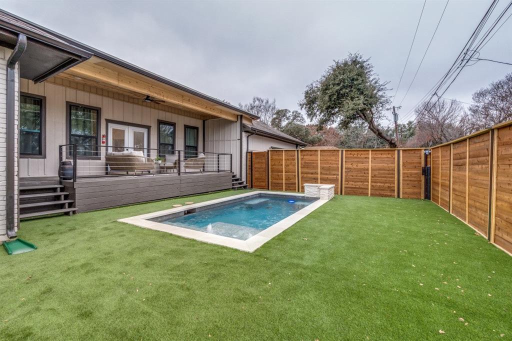 7115 Meadow Road Dallas, TX 75230 - Photo 21 of 22 The property features a private backyard with a swimming pool, a wooden deck, and a wood privacy fence
