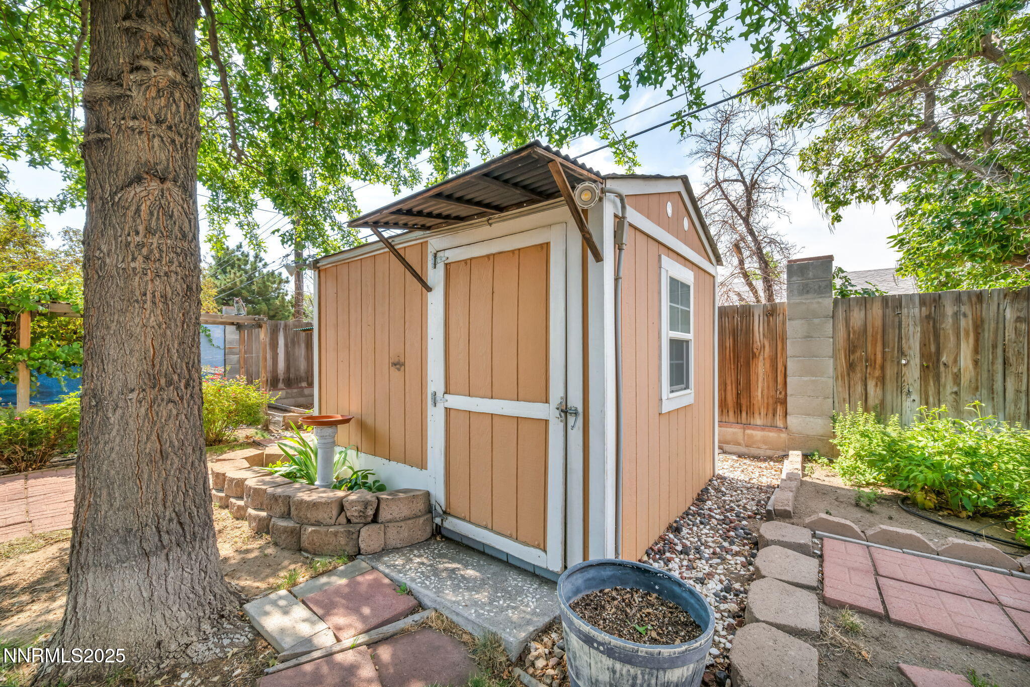 3570 West 7th Street Reno, NV 89503 - Photo 45 of 45 a backyard of a house with dining table and chairs with a large tree