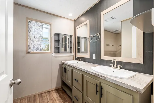 a bathroom with a granite countertop sink and two mirror