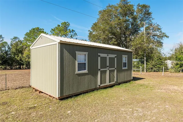 a view of a house with backyard and sitting area