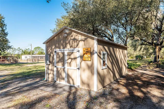 a view of a house with backyard and trees