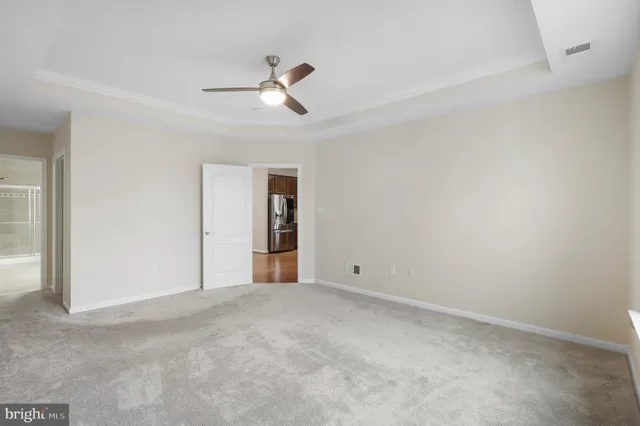 a view of an empty room with chandelier fan