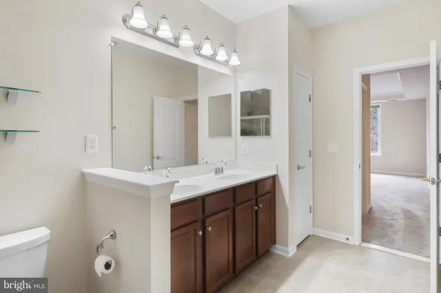 a bathroom with a sink double vanity granite and a mirror