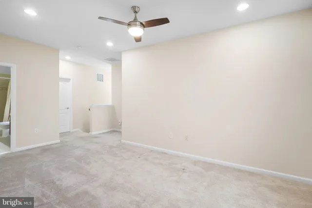 en empty room with ceiling fan and window