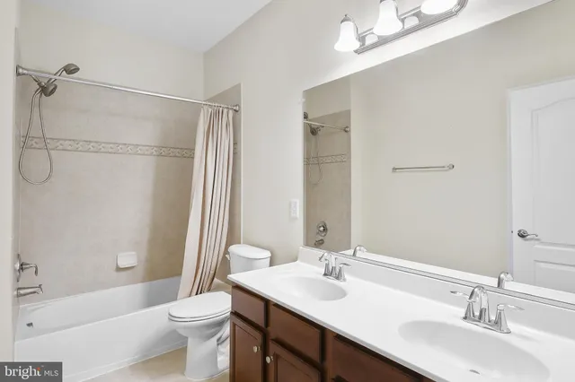 a bathroom with a double vanity sink toilet mirror and shower