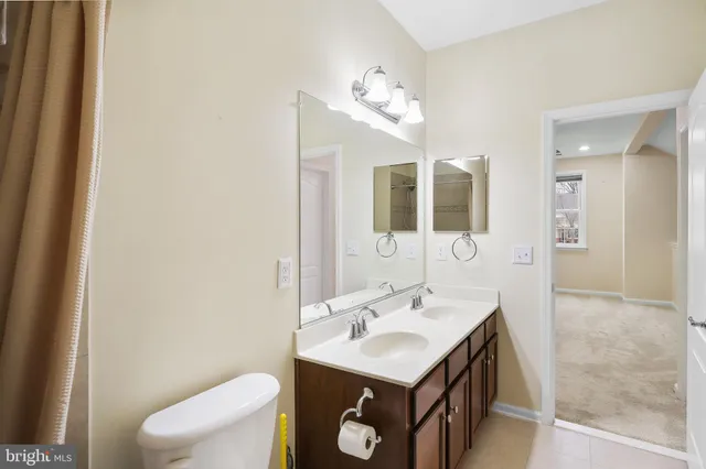 a bathroom with a sink a toilet and mirror