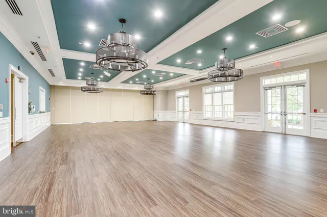 a view of a room with lots of wooden floor and chandelier