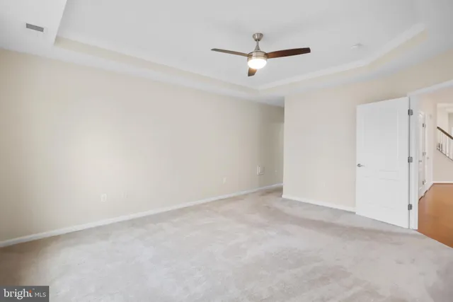 an empty room with a ceiling fan and window