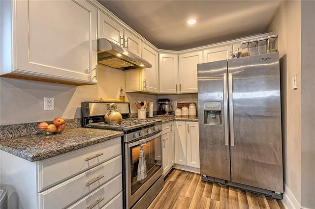 a kitchen with stainless steel appliances granite countertop a sink stove and refrigerator