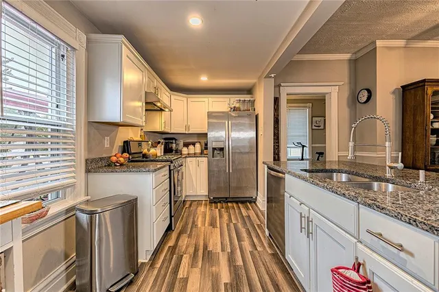 a kitchen with granite countertop stainless steel appliances a sink and counter space