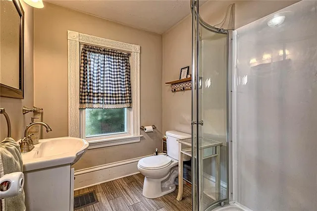 a bathroom with a granite countertop toilet a sink and a mirror