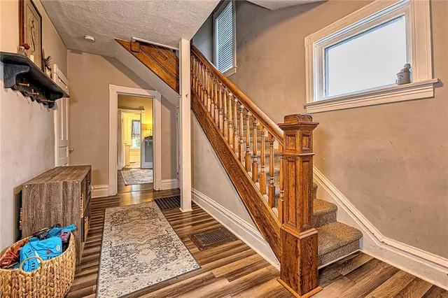 a view of entryway and hall with wooden floor