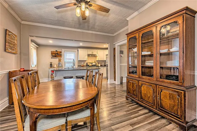 a dining room with furniture a floor to ceiling window and wooden floor