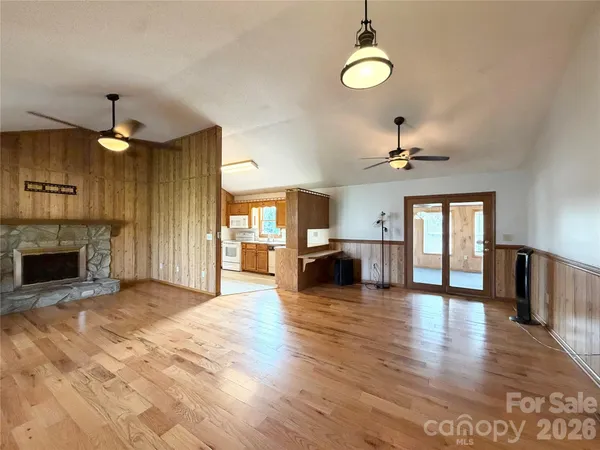 a view of a livingroom with a fireplace a chandelier and windows