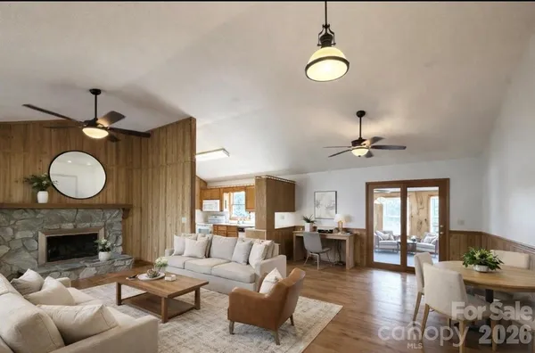 a living room with furniture a fireplace and a large window