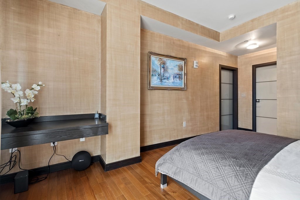 2400 Beacon Street, Unit 401 Boston, MA 02467 - Photo 17 of 35 a bedroom with a bed and wooden floor
