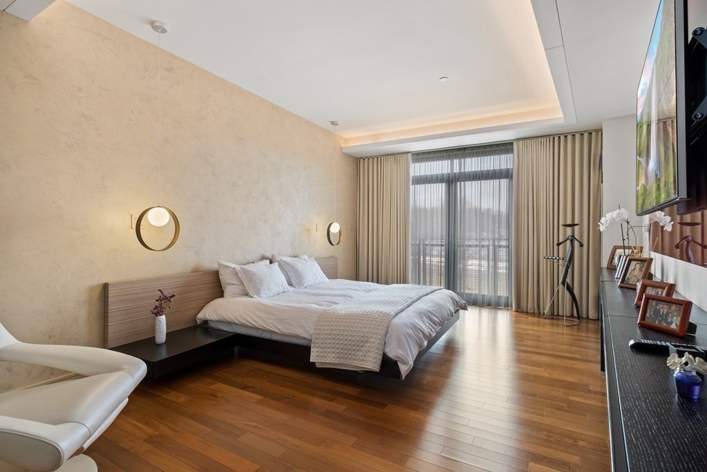 2400 Beacon Street, Unit 401 Boston, MA 02467 - Photo 21 of 35 a bedroom with a bed and wooden floor