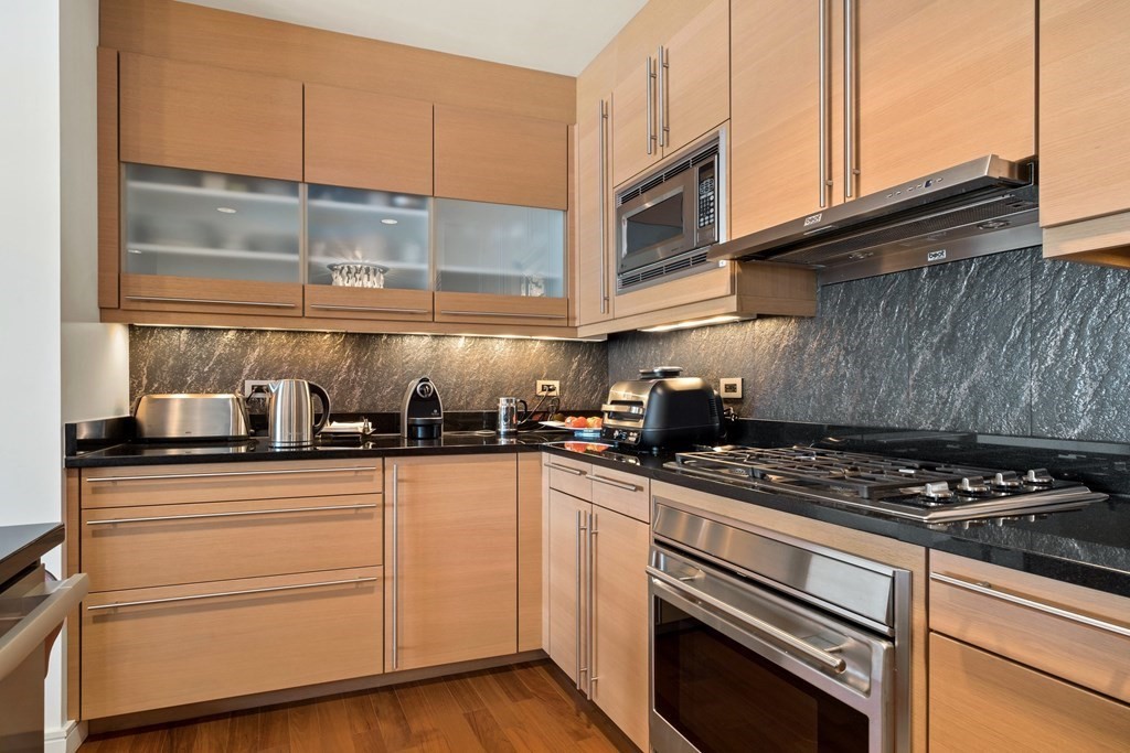 2400 Beacon Street, Unit 401 Boston, MA 02467 - Photo 5 of 35 a kitchen with granite countertop stainless steel appliances and white cabinets
