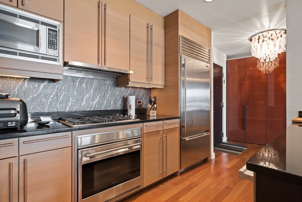 2400 Beacon Street, Unit 401 Boston, MA 02467 - Photo 6 of 35 a kitchen with stainless steel appliances granite countertop a refrigerator stove and sink