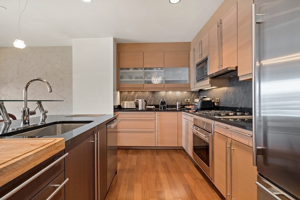 2400 Beacon Street, Unit 401 Boston, MA 02467 - Photo 8 of 35 a kitchen with granite countertop a sink stainless steel appliances and cabinets