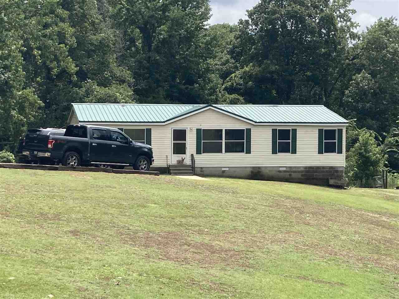 6884 Conner Whitefield Road Ripley, TN 38063 - Photo 2 of 16 a front view of a house with a garden and swimming pool
