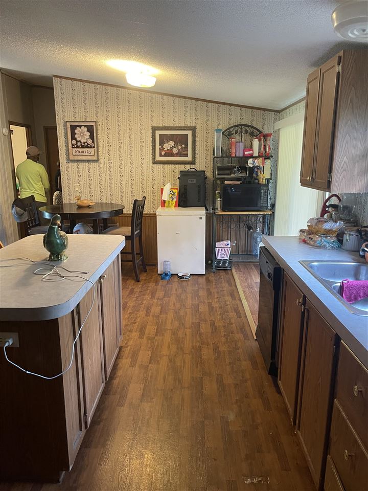 6884 Conner Whitefield Road Ripley, TN 38063 - Photo 4 of 16 a kitchen with a sink stove and wooden cabinets