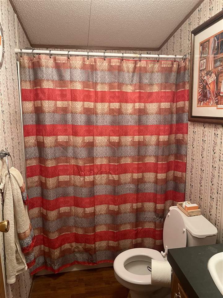 6884 Conner Whitefield Road Ripley, TN 38063 - Photo 7 of 16 a bathroom with a sink toilet and shower curtain
