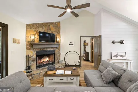 a living room with furniture a flat screen tv and a fireplace