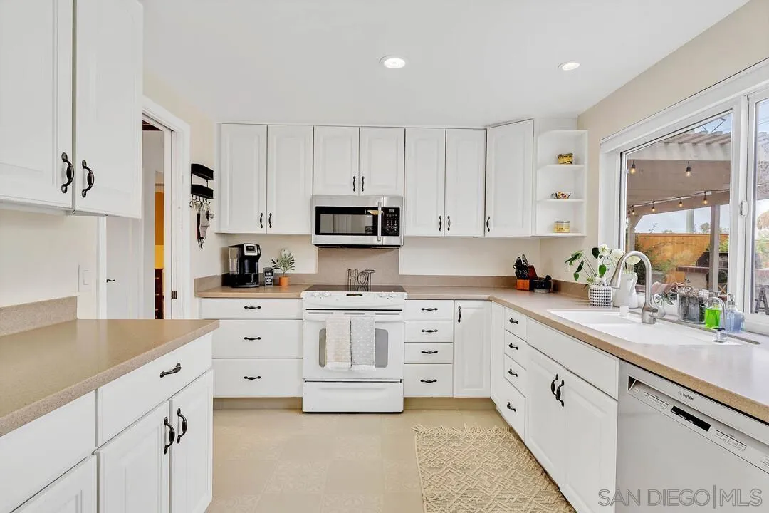 1668 Olmeda Street Encinitas, CA 92024 - Photo 11 of 42 a kitchen with white cabinets and white appliances