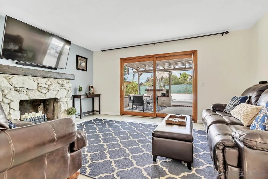 1668 Olmeda Street Encinitas, CA 92024 - Photo 13 of 42 a living room with furniture a flat screen tv and a fireplace