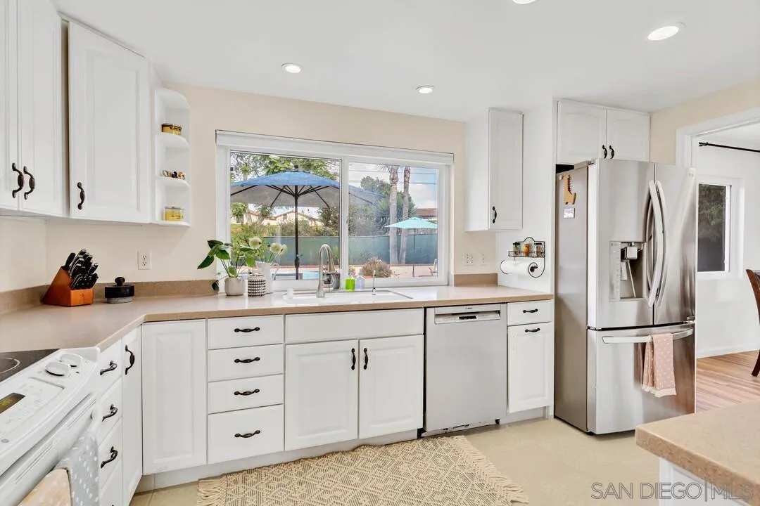1668 Olmeda Street Encinitas, CA 92024 - Photo 10 of 42 a kitchen with white cabinets and refrigerator