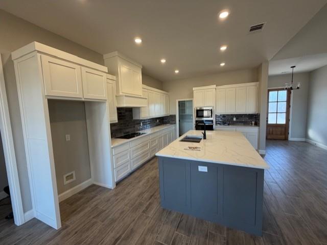230 Kilkenny Road Poolville, TX 76487 - Photo 9 of 22 a large kitchen with stainless steel appliances a large counter top a stove and a refrigerator