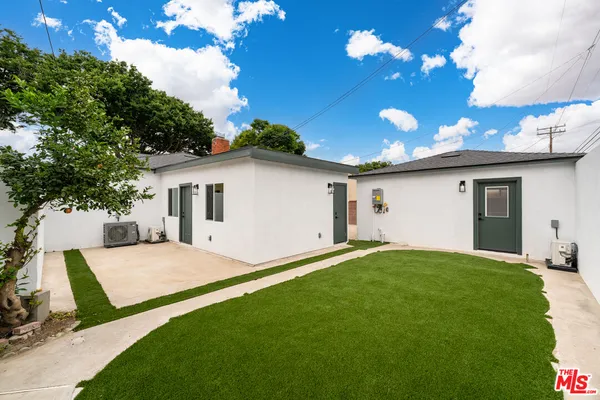 a view of a house with backyard and sitting area