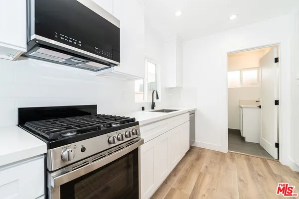 a kitchen with granite countertop a stove and a sink