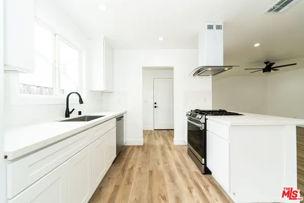 a kitchen with a sink a stove and cabinets