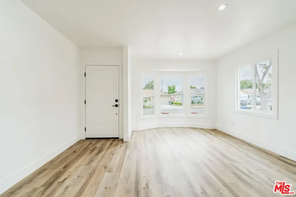 a view of a room with wooden floor and window