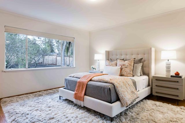 a bedroom with a bed lamp and window