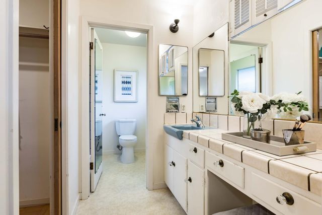 a bathroom with a sink and mirror with toilet